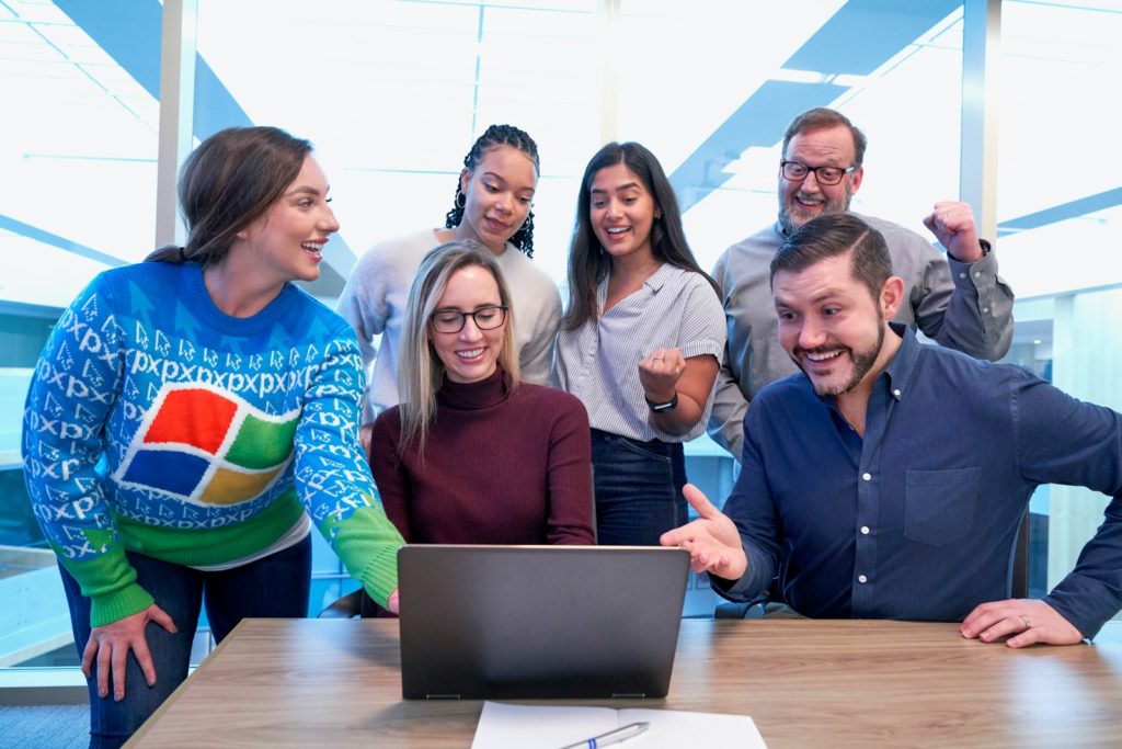 woman in maroon sweater using laptop to take part in employee listening programme.