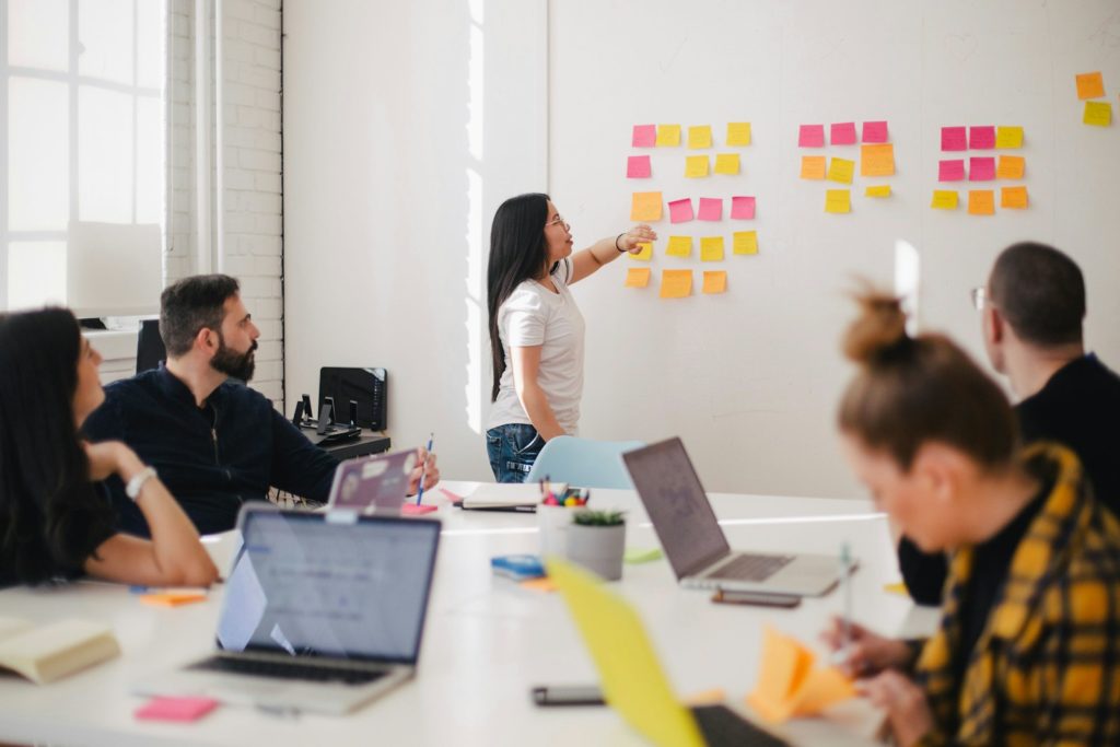 woman placing sticky notes on wall for employee feedback session